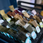 Hair color samples showing various shades are displayed, ready for a hairdresser to select the perfect match for a young female model's new look